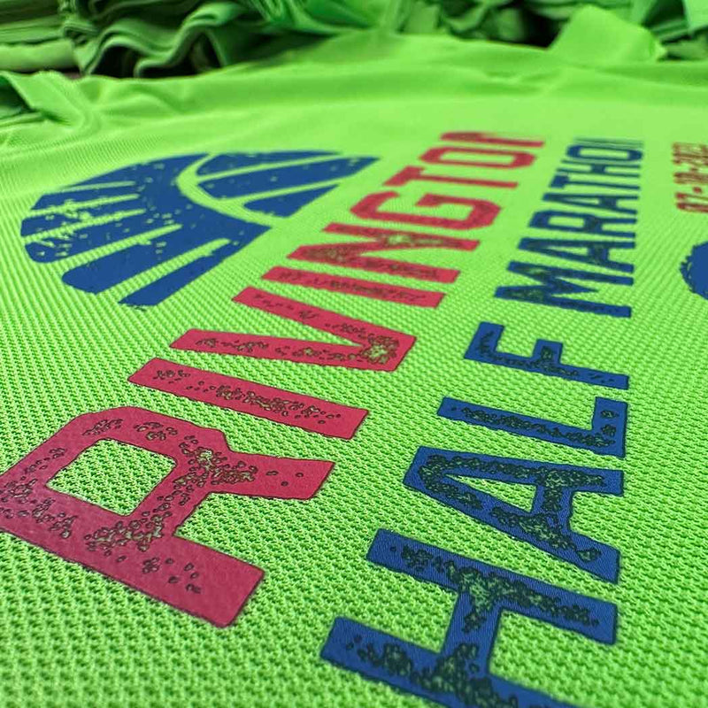 Green running shirt with colorful text and logos on a green background