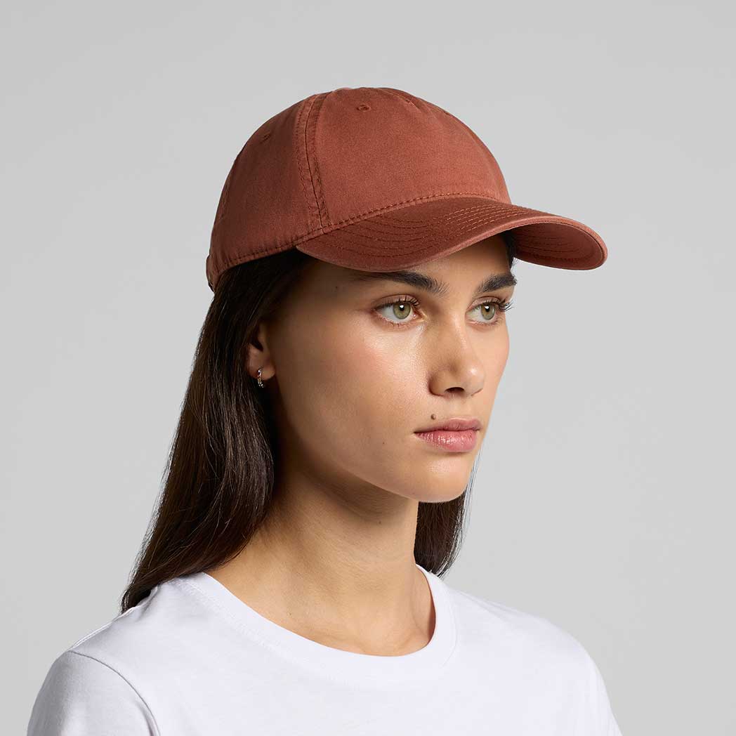 Woman wearing a brown cap against a gray background