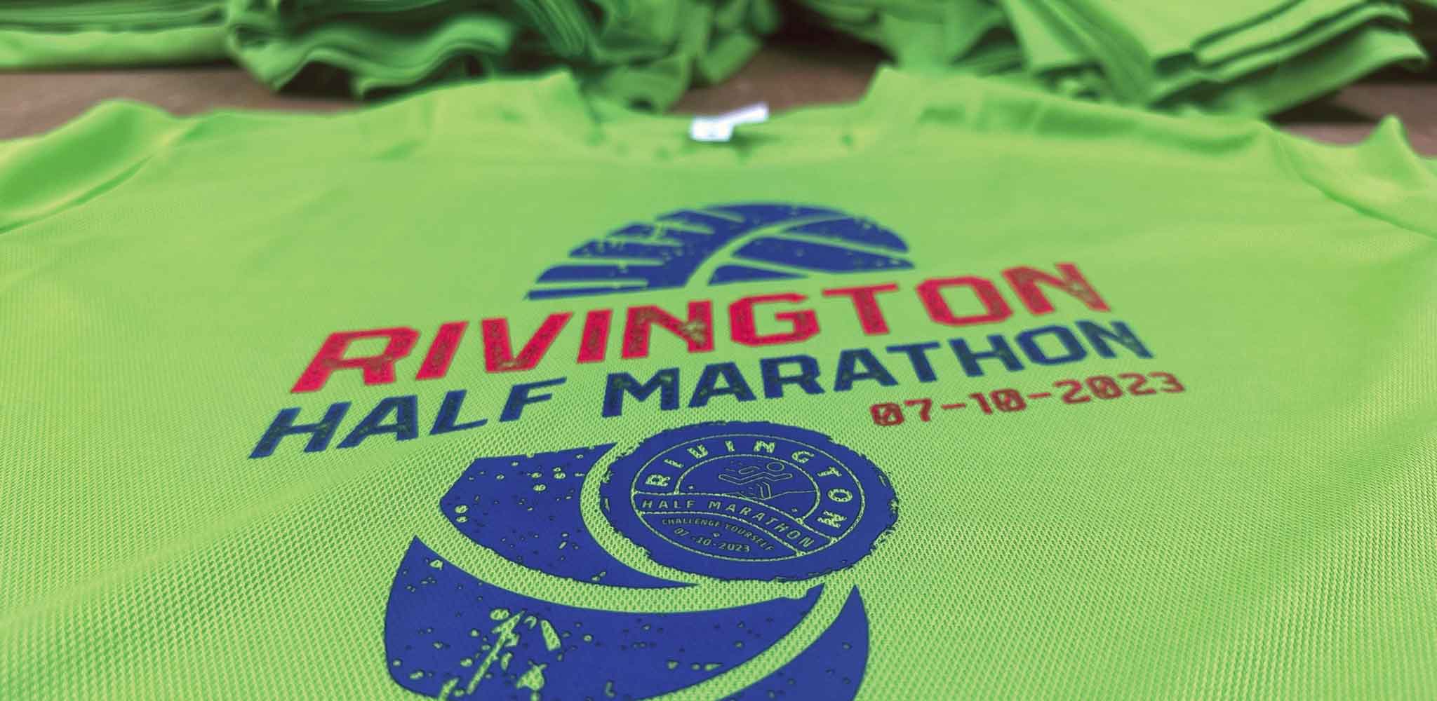 A printed t-shirt of the Rivington Half Marathon 2023 event laid on a table