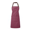 A burgundy bib-apron with a leather-like adjustable strap at the neck and a pen pocket on the front. It is displayed against a white background. Premier Annex Oxford Bib Apron - PR144
