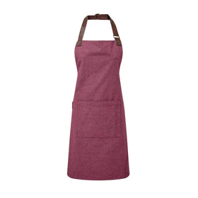 A burgundy bib-apron with a leather-like adjustable strap at the neck and a pen pocket on the front. It is displayed against a white background. Premier Annex Oxford Bib Apron - PR144