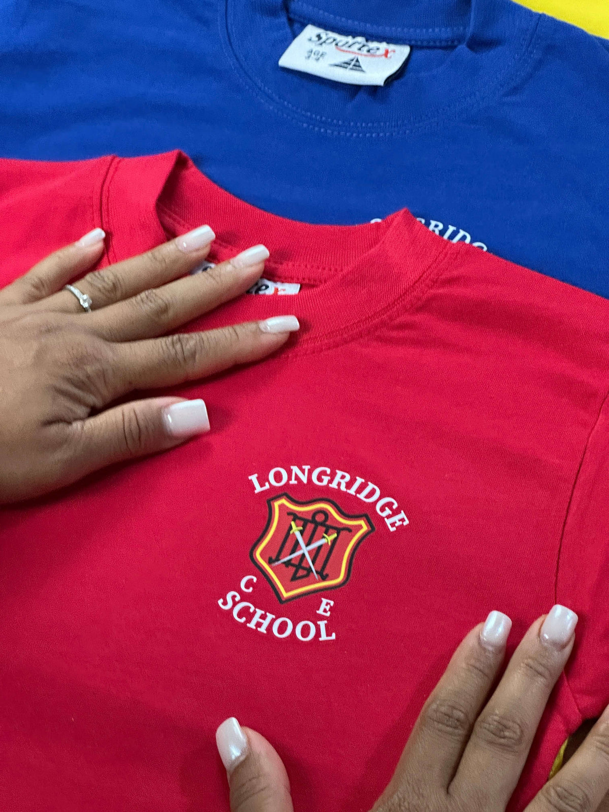 A red t-shirt with a 'Longridge C.of E School printed on the left chest.