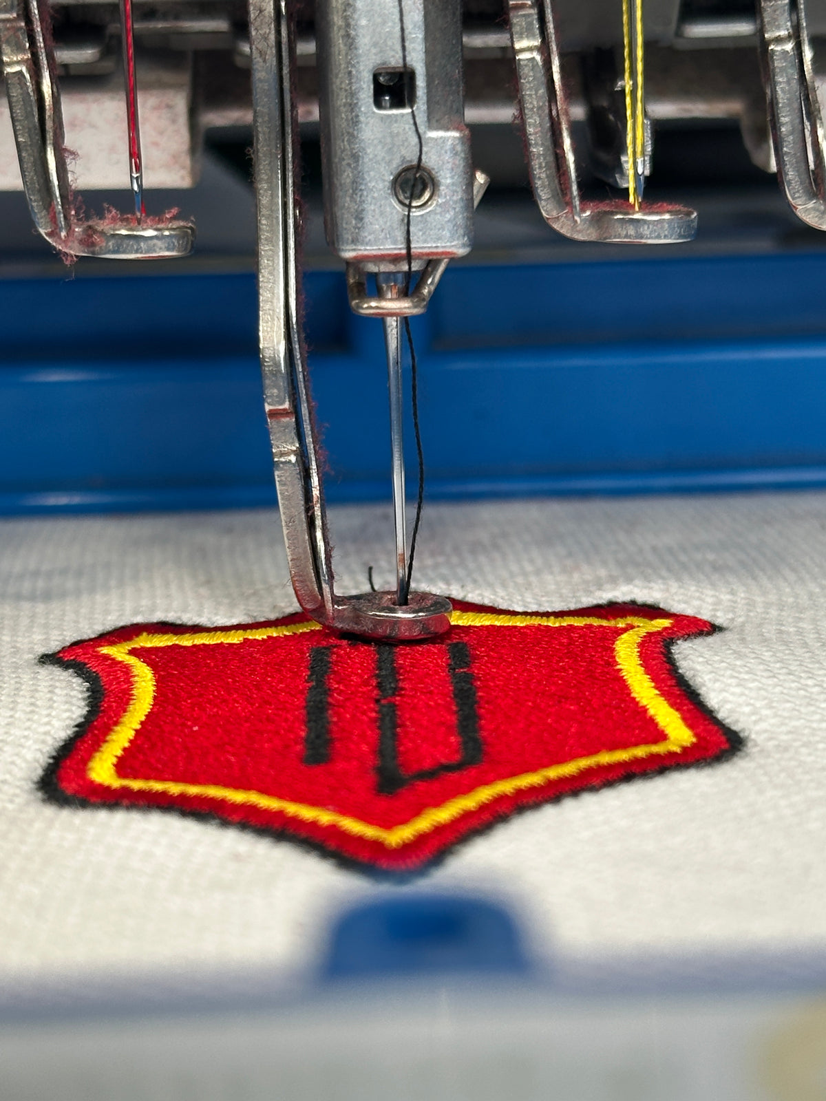 Stitching the lettering around the crest
