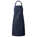 An indigo blue denim bib apron with a center pocket, adjustable neck strap, displayed against a white background. Denim Bib Apron with Pocket - PR154