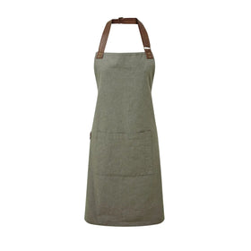 A moss green bib-apron with a pen pocket and brown straps, made of cotton fabric. It is displayed against a white background Premier Annex Oxford Bib Apron - PR144