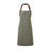 A moss green bib-apron with a pen pocket and brown straps, made of cotton fabric. It is displayed against a white background Premier Annex Oxford Bib Apron - PR144