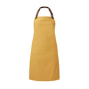 A mustard yellow bib-apron with a leather-like adjustable strap at the neck and a pen pocket on the front. It is displayed against a white background. Premier Annex Oxford Bib Apron - PR144