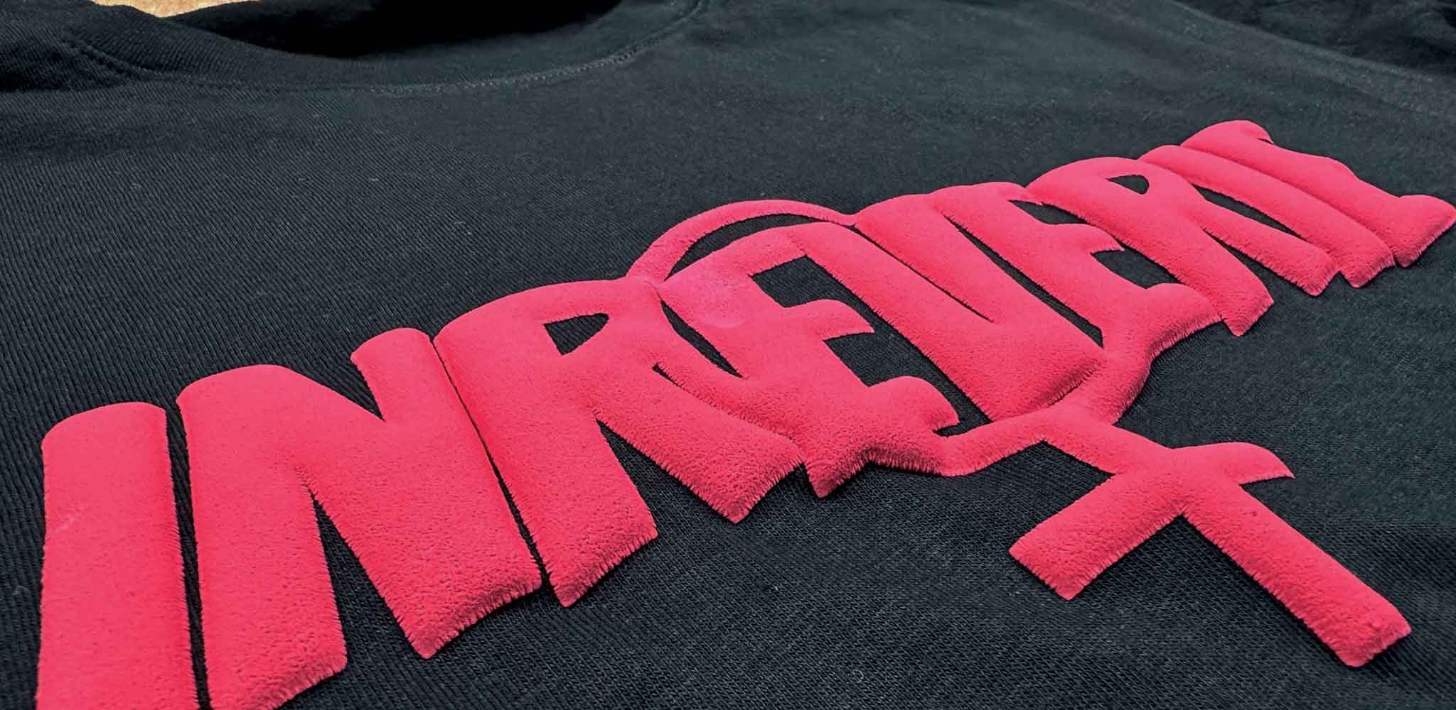 A close-up image of a red puff print on a  black t-shirt