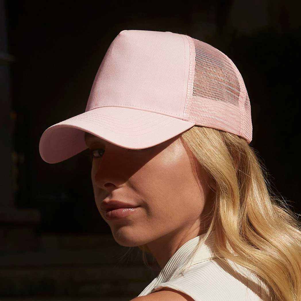 Person wearing a pink cap with a dark background