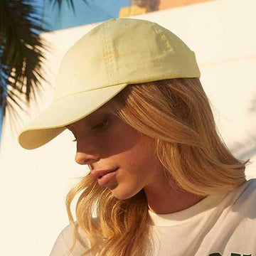 Woman wearing Beechfield Dad Cap - B653 in pastel lemon in an outdoor setting