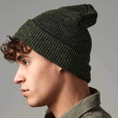 Person wearing a green knit beanie against a gray background