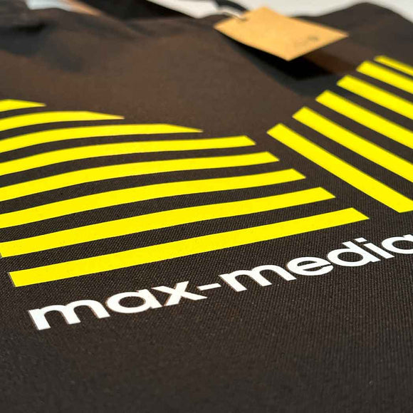 Black tote-bag with yellow and white striped design and 'max-media' text.