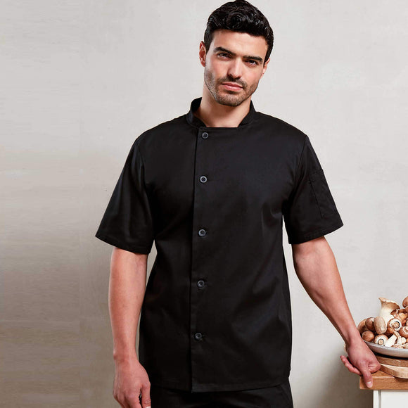 A model wearing a black short sleeve chef's jacket with resin button fastening and a mandarin collar. Premier Chef's Essential Short Sleeve Jacket - PR900