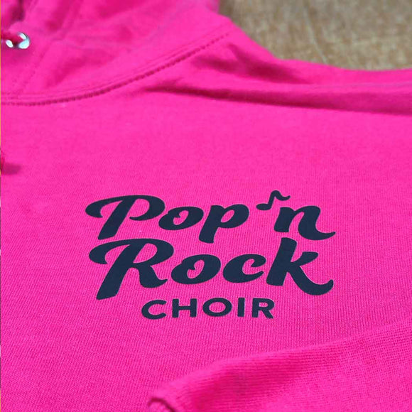 Pink hoodie with 'Pop n Rock Choir' text on a blurred background