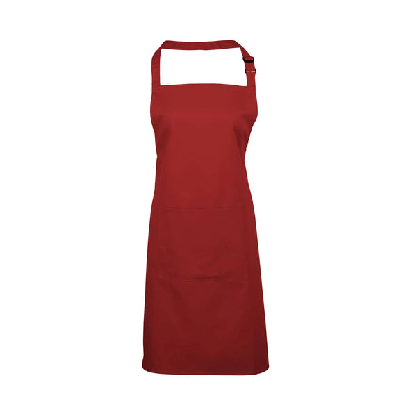 A red bib apron with a neck strap and front pocket, displayed on a plain background. Colours Bib Apron with Pocket - PR154