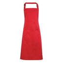 A strawberry red bib apron with a neck strap and front pocket, displayed on a plain background. Colours Bib Apron with Pocket - PR154