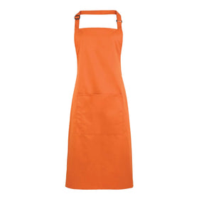 A terracotta bib apron with a neck strap and front pocket, displayed on a plain background. Colours Bib Apron with Pocket - PR154
